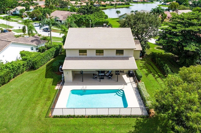 back of house featuring a patio area, a yard, a water view, and a fenced in pool