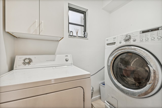 laundry room with washer and dryer and cabinets