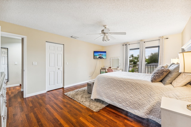 bedroom featuring access to exterior, dark hardwood / wood-style flooring, a textured ceiling, and ceiling fan