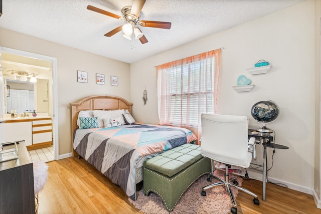 bedroom with light wood-type flooring, ceiling fan, connected bathroom, and a textured ceiling