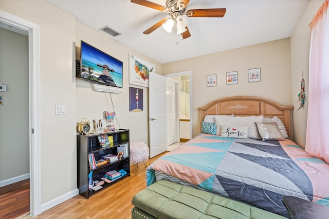 bedroom featuring ceiling fan, wood-type flooring, and a textured ceiling