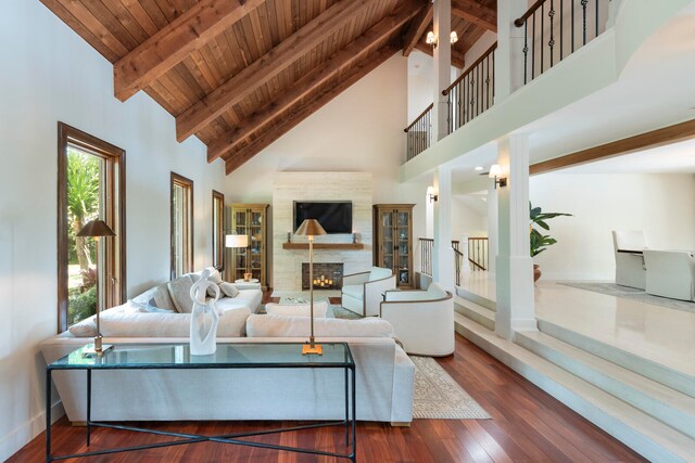 living room with high vaulted ceiling, beam ceiling, dark wood-type flooring, and wooden ceiling