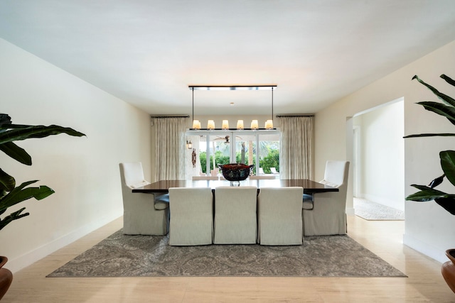 dining space with light wood-type flooring and rail lighting