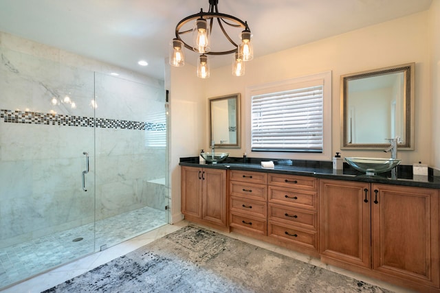 bathroom with a shower with door, tile patterned floors, a notable chandelier, and vanity