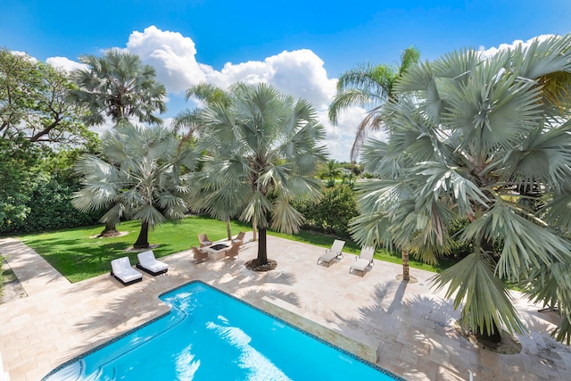 view of swimming pool featuring a yard, a patio, and a fire pit