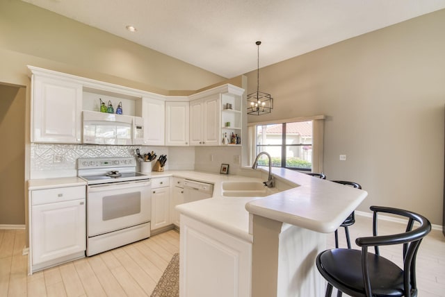 kitchen featuring white appliances, decorative light fixtures, white cabinetry, and sink