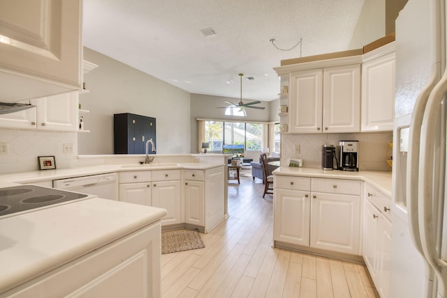 kitchen with white appliances, white cabinets, sink, ceiling fan, and kitchen peninsula