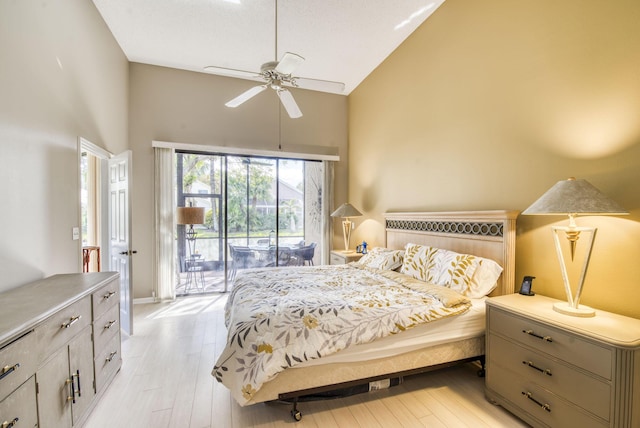 bedroom featuring access to exterior, light hardwood / wood-style floors, high vaulted ceiling, and ceiling fan