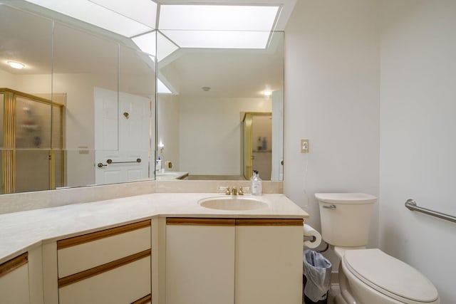 bathroom featuring vanity, toilet, and a shower with shower door