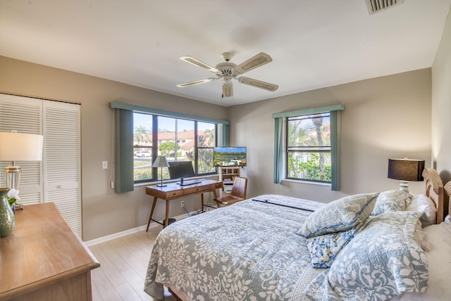 bedroom with light wood-type flooring, a closet, and ceiling fan