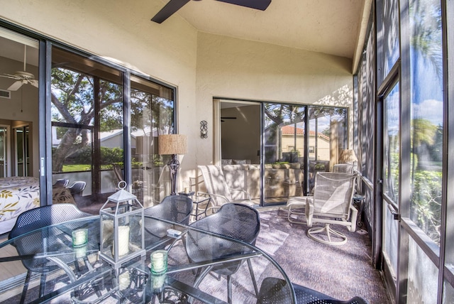 sunroom with ceiling fan and vaulted ceiling