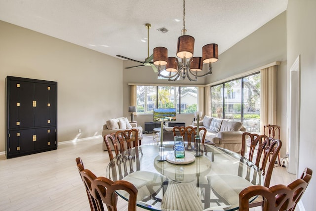 dining room featuring high vaulted ceiling, light hardwood / wood-style floors, a textured ceiling, and a notable chandelier