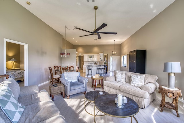 living room featuring ceiling fan, light hardwood / wood-style flooring, and high vaulted ceiling