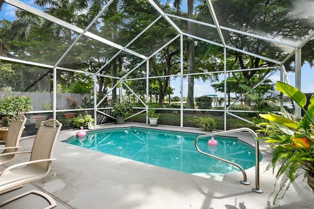 view of pool featuring glass enclosure and a patio