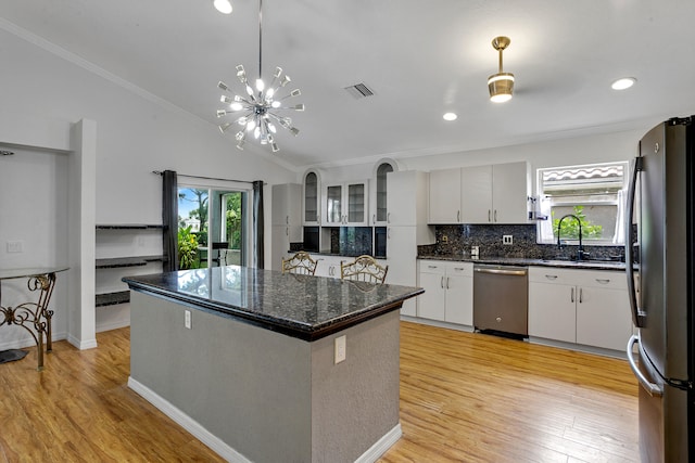 kitchen featuring appliances with stainless steel finishes, light wood-type flooring, white cabinetry, and sink