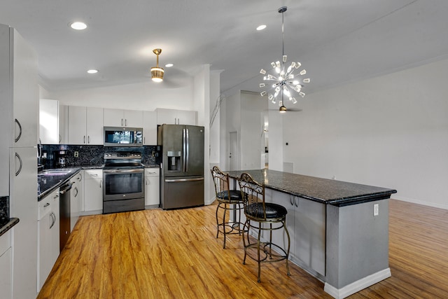 kitchen featuring light hardwood / wood-style flooring, appliances with stainless steel finishes, pendant lighting, and white cabinetry