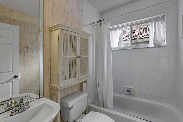 full bathroom featuring sink, shower / tub combo with curtain, and toilet