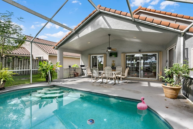 view of swimming pool with ceiling fan, a patio, and a lanai