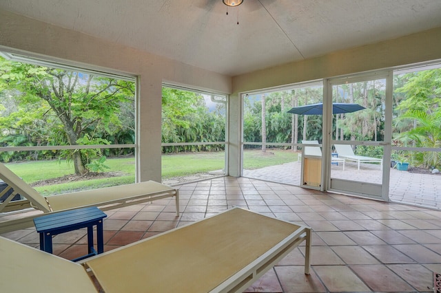 unfurnished sunroom featuring ceiling fan