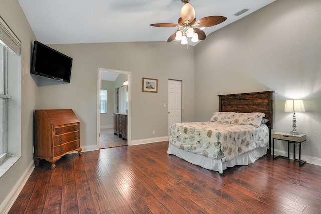 bedroom featuring ceiling fan, a closet, ensuite bath, lofted ceiling, and dark hardwood / wood-style floors