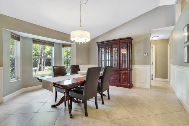 tiled dining space with vaulted ceiling and a chandelier