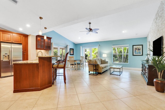 living room with lofted ceiling, light tile patterned flooring, and ceiling fan