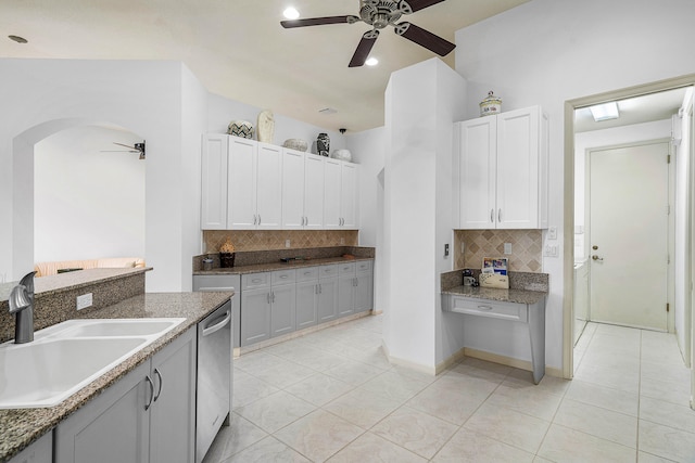 kitchen featuring ceiling fan, decorative backsplash, stainless steel dishwasher, sink, and white cabinetry