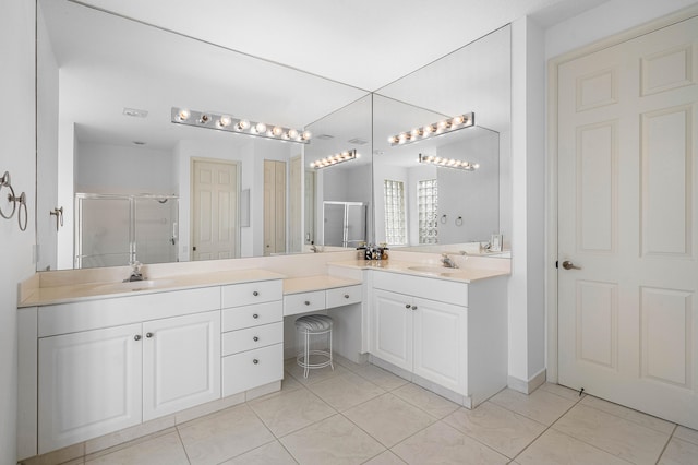 bathroom featuring tile patterned floors, a shower with door, and vanity