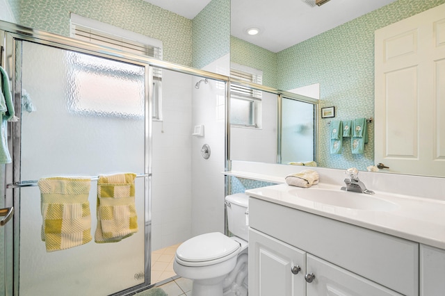 bathroom featuring tile patterned flooring, a shower with door, vanity, and toilet