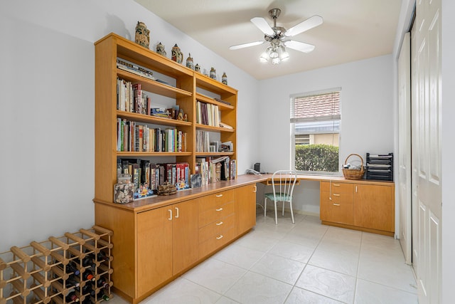 tiled office with ceiling fan and built in desk