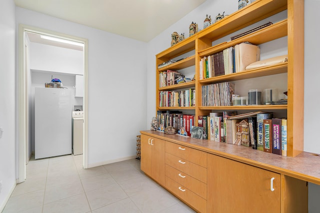 hallway featuring light tile patterned flooring and washer / dryer