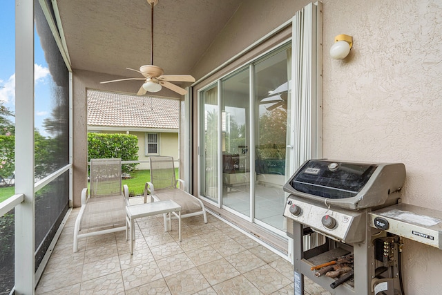 unfurnished sunroom featuring ceiling fan and a wealth of natural light