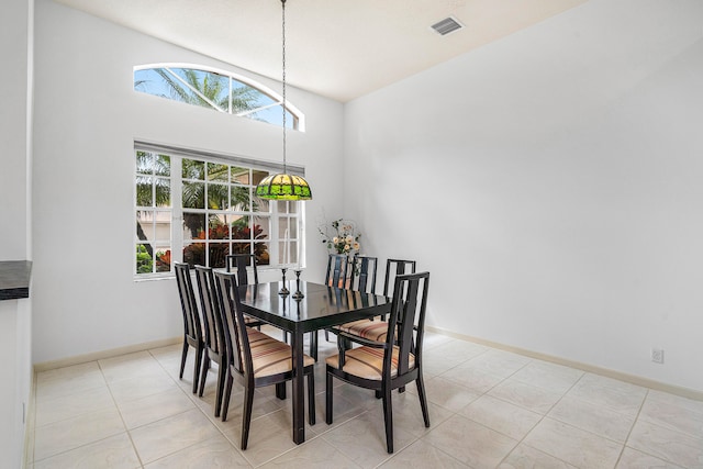 dining room with high vaulted ceiling and light tile patterned floors