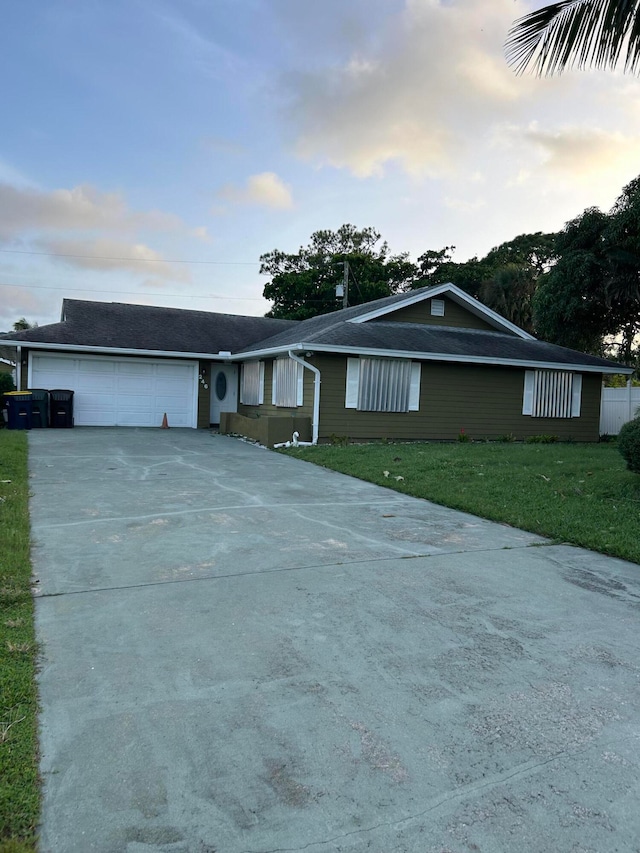 ranch-style home featuring a garage and a yard