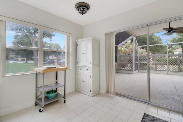 interior space featuring light tile patterned floors and ceiling fan