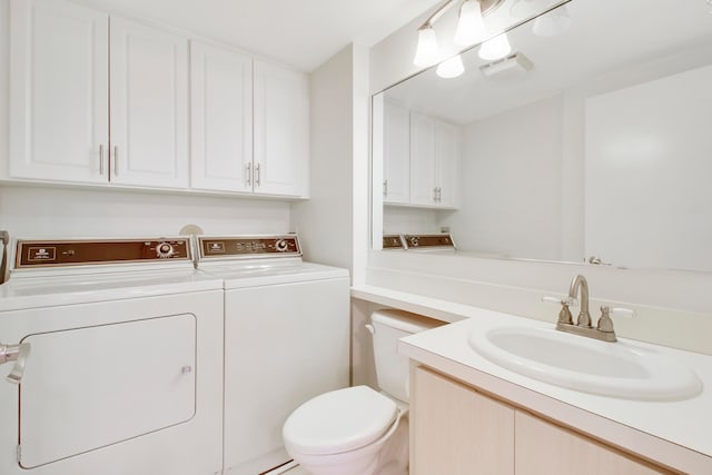 bathroom with vanity, washer and dryer, and toilet