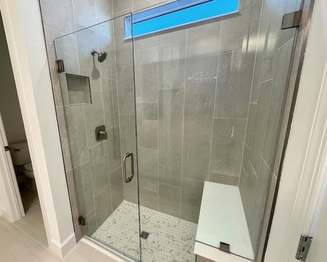 full bath featuring tile patterned floors, a shower stall, and toilet