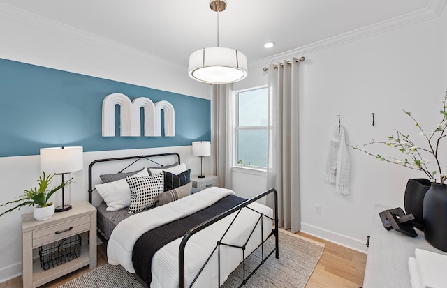 bedroom with light wood finished floors, crown molding, and baseboards