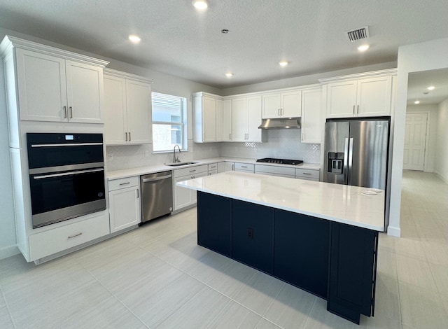 kitchen with visible vents, a sink, stainless steel appliances, under cabinet range hood, and white cabinetry