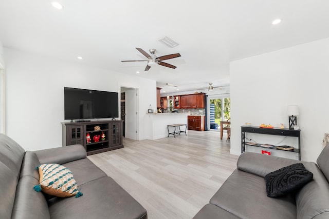 living room featuring light hardwood / wood-style flooring and ceiling fan