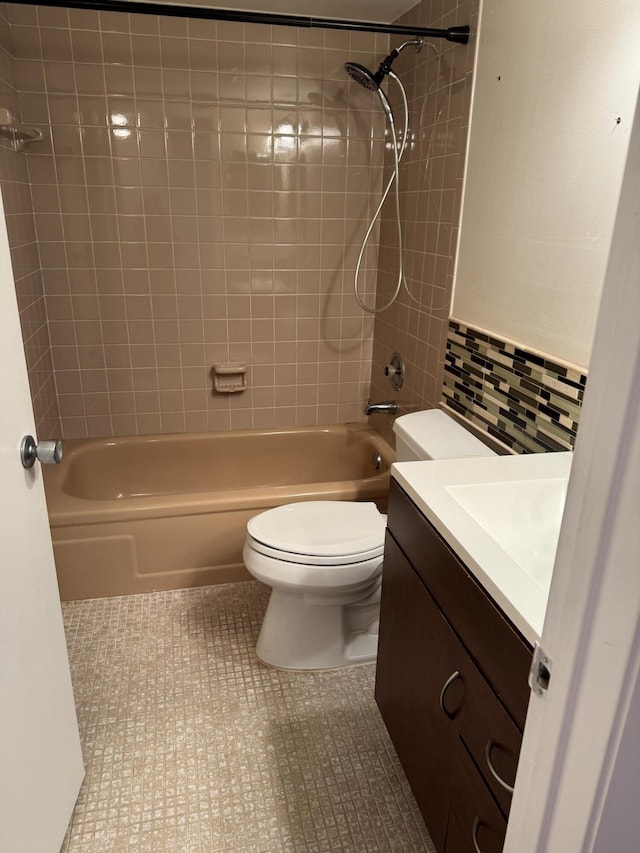 full bathroom with tiled shower / bath combo, tile patterned flooring, backsplash, toilet, and vanity