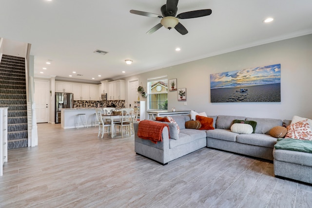 kitchen featuring light stone counters, kitchen peninsula, appliances with stainless steel finishes, crown molding, and a kitchen bar