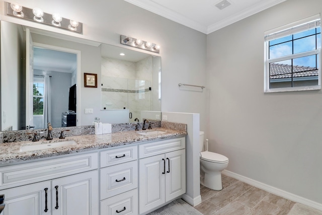 bathroom featuring a tile shower, vanity, crown molding, and toilet