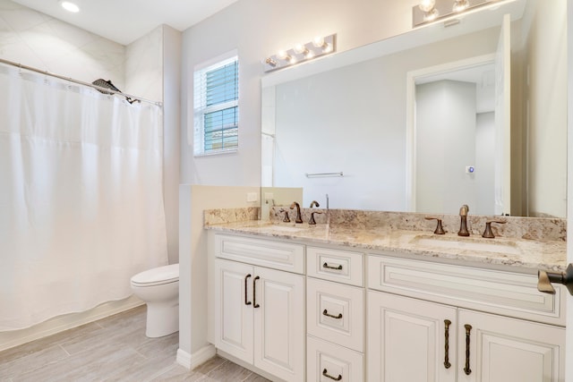 bathroom with wood-type flooring, vanity, and toilet