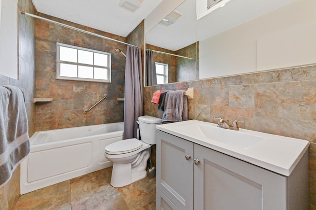 full bathroom with shower / bath combo, vanity, tile walls, and toilet