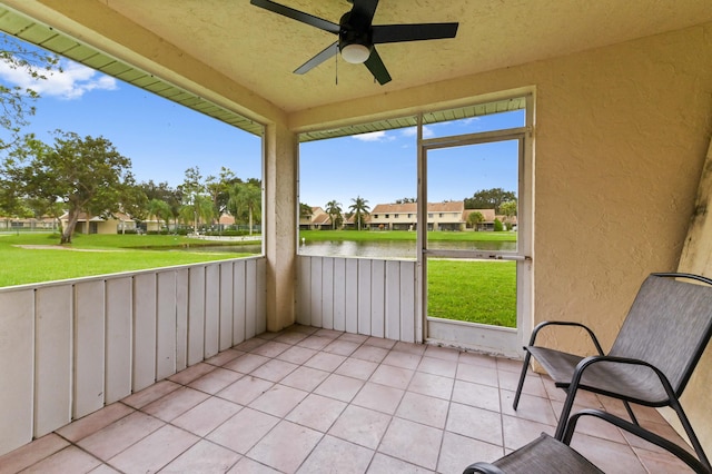 unfurnished sunroom with a water view and ceiling fan