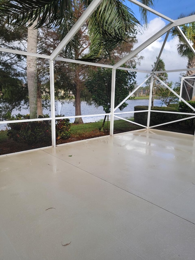 view of patio featuring a lanai and a water view