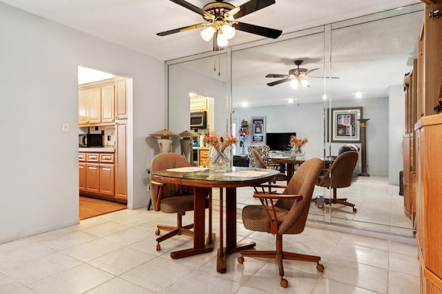 dining space featuring light tile patterned flooring and ceiling fan