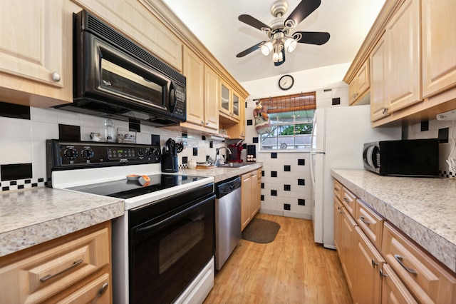 kitchen with appliances with stainless steel finishes, backsplash, light wood-type flooring, ceiling fan, and sink