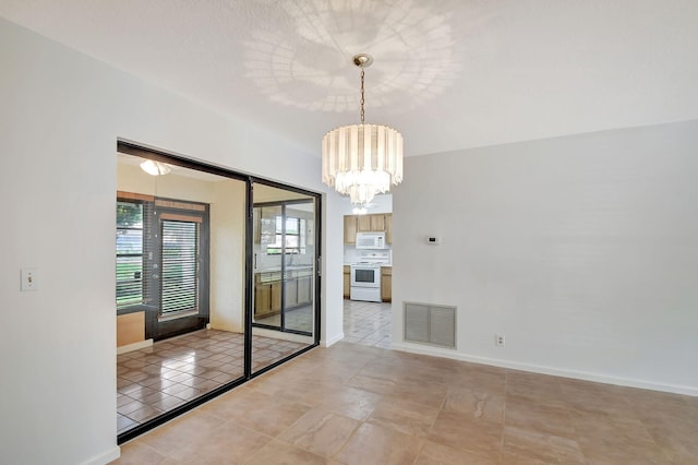 unfurnished room featuring a chandelier and light tile patterned floors